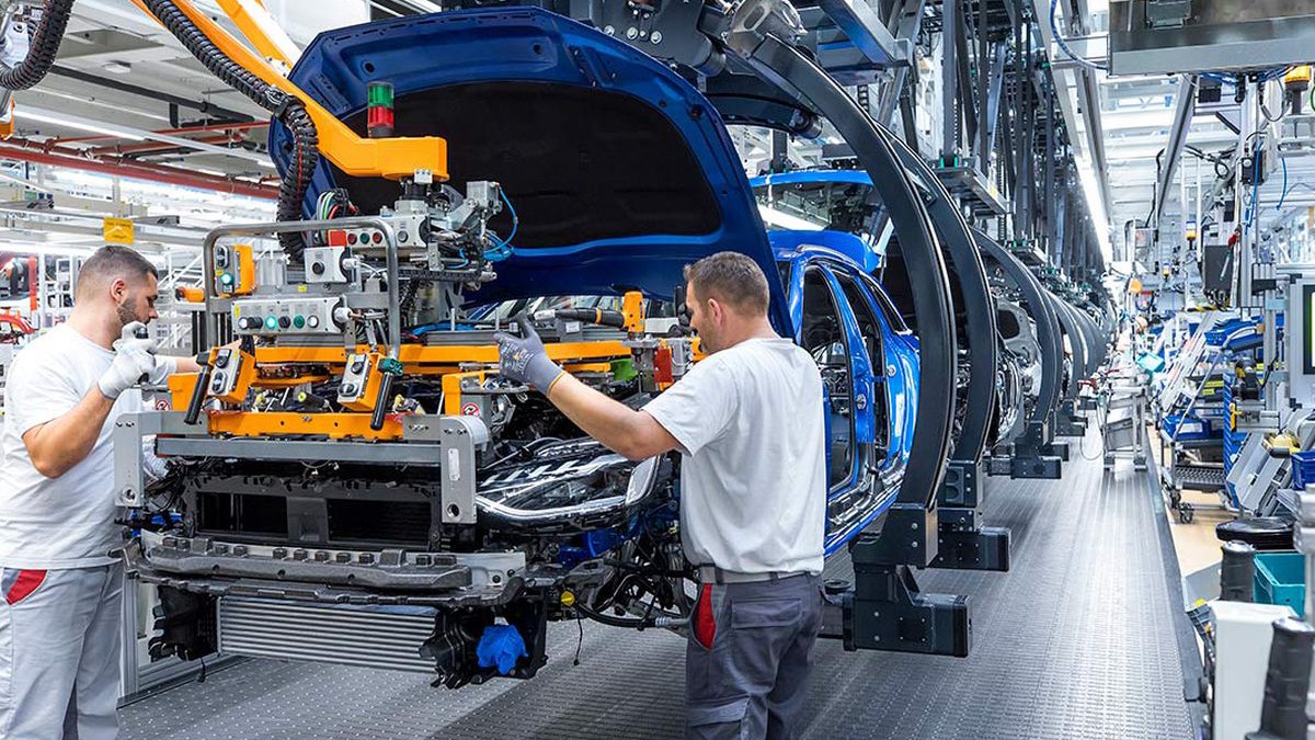 Línea de montaje moderna con brazos robotizados ensamblando un coche
